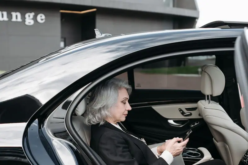 Woman in the back seat of a black Mercedes