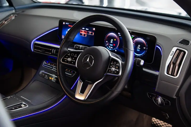 Dashboard and steering wheel of a Mercedes with blue lighting