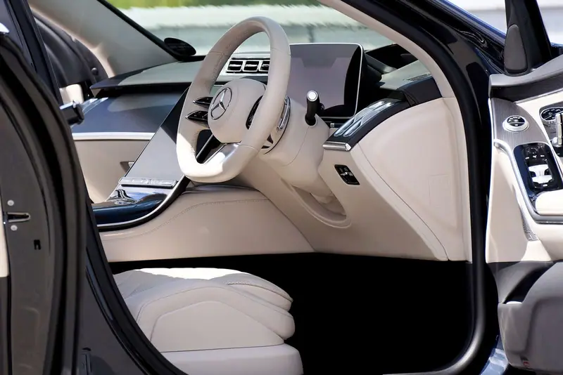 Front seats of a luxury sedan with a large screen