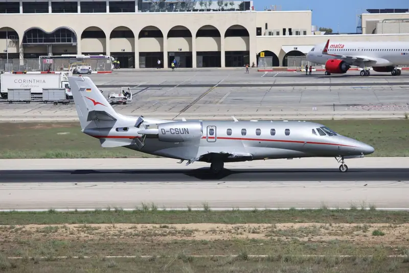 Private jet on the runway beside an airport building
