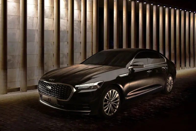 Dark luxury sedan parked in a hall with warm lights