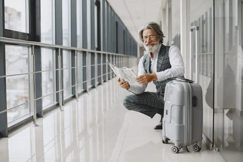 Traveller with a suitcase reading a map in a bright corridor