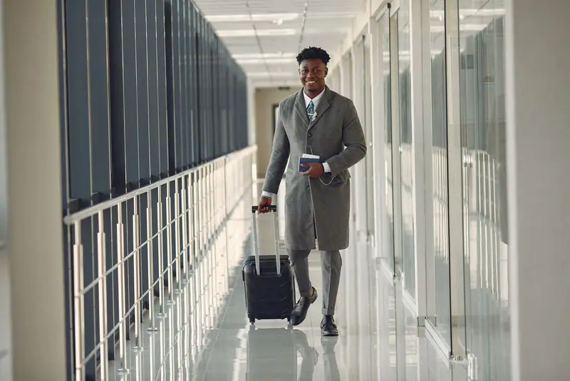 Businessman pulling a suitcase through a bright corridor