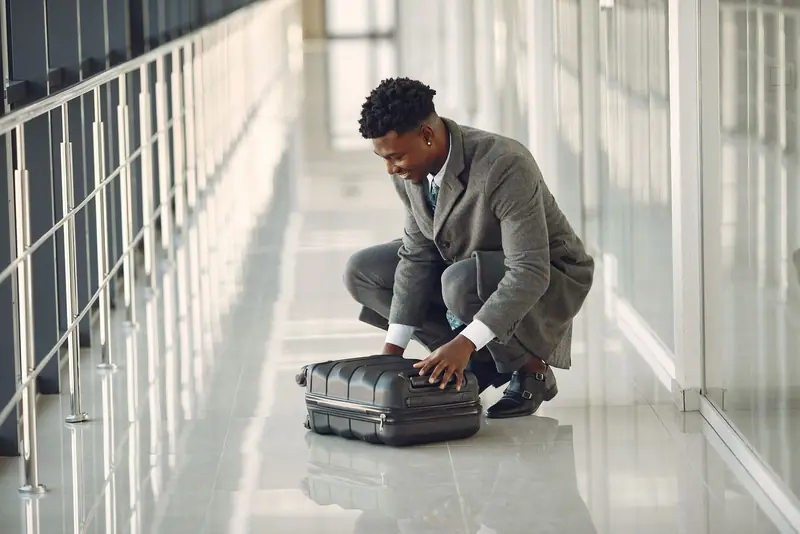 Traveller packing a suitcase in a bright corridor