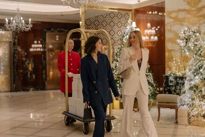 Hotel guests arriving with a bellhop and a luggage cart