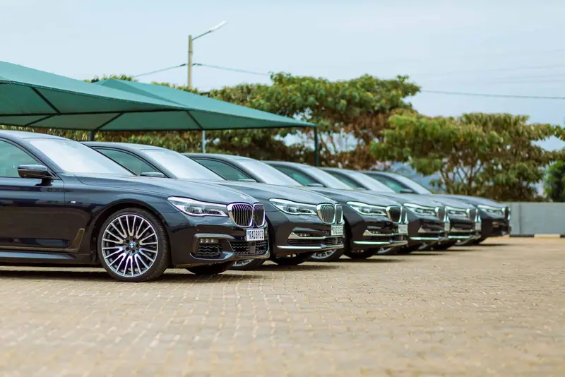Row of black BMW 7 Series sedans parked in a line outside