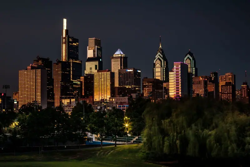 Philadelphia skyline at night above a park