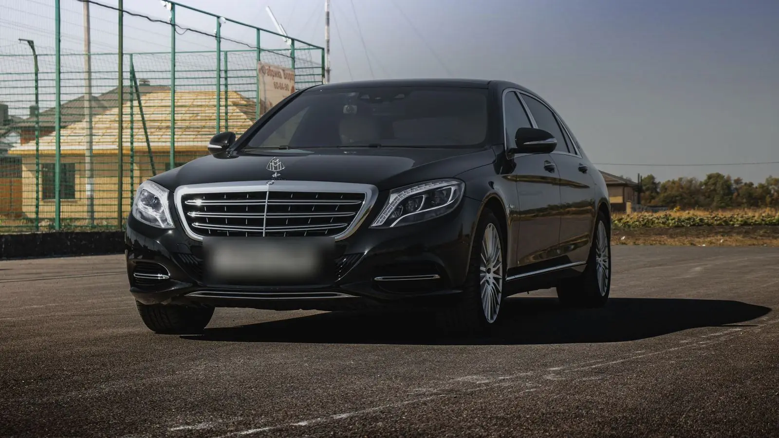 Black Mercedes-Maybach S-Class sedan parked on an empty lot